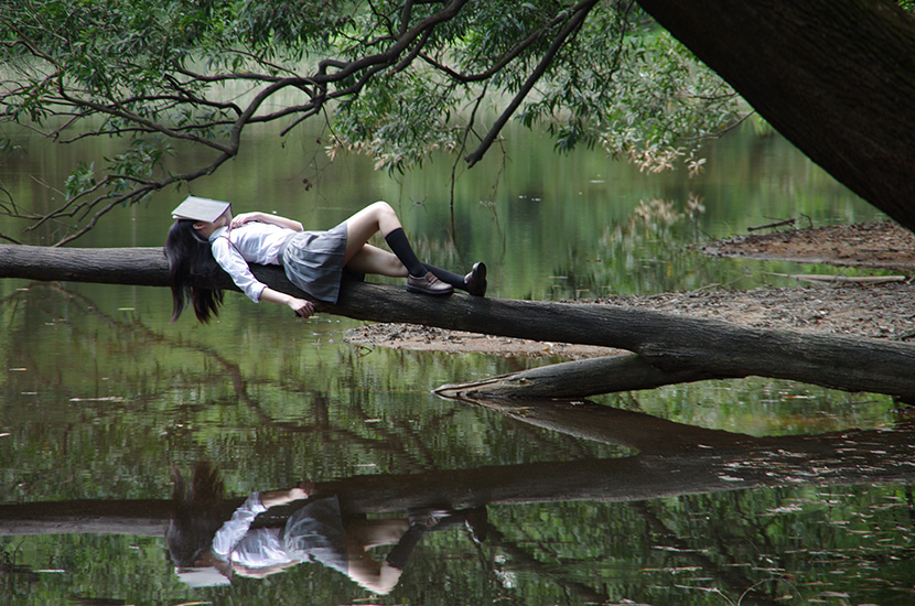 躺在树杆上的学生服女孩
